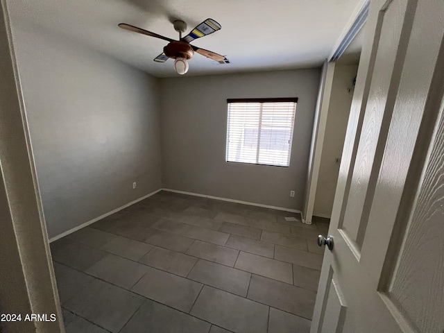 unfurnished bedroom with dark tile patterned floors and ceiling fan