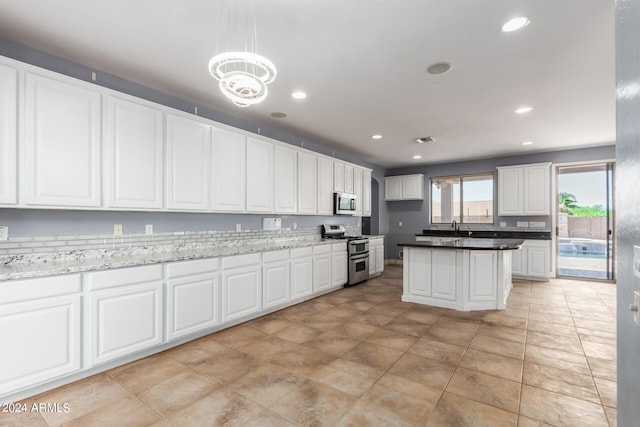 kitchen with white cabinetry, light stone countertops, pendant lighting, stainless steel appliances, and a notable chandelier