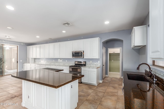 kitchen featuring light tile patterned floors, stainless steel appliances, sink, and white cabinetry