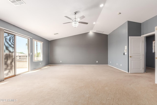 carpeted spare room featuring vaulted ceiling and ceiling fan