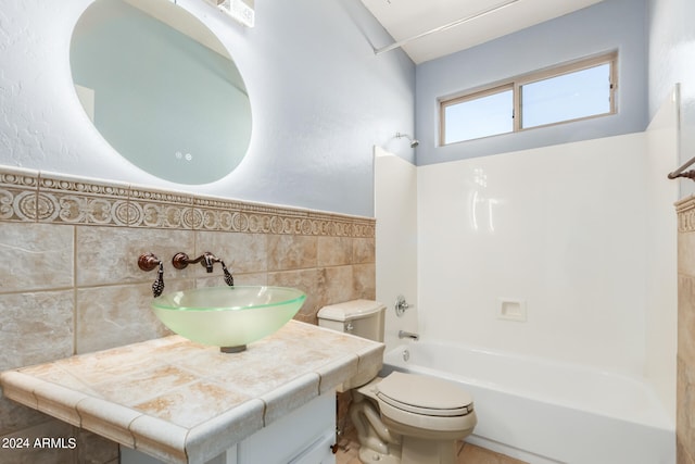 full bathroom with tile walls, shower / tub combination, vanity, and toilet