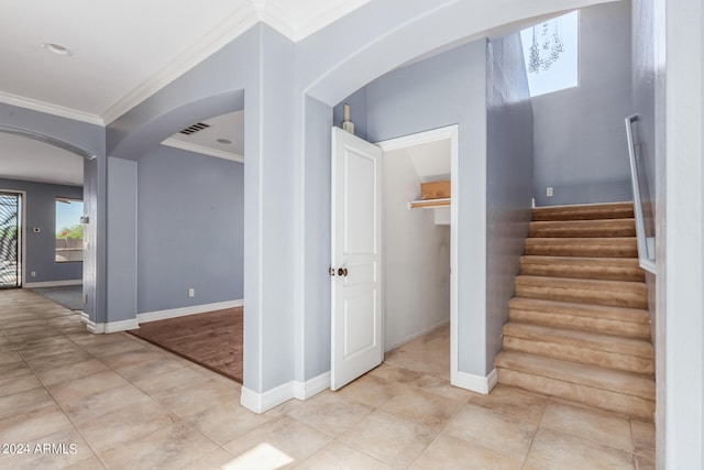 staircase with tile patterned flooring and ornamental molding