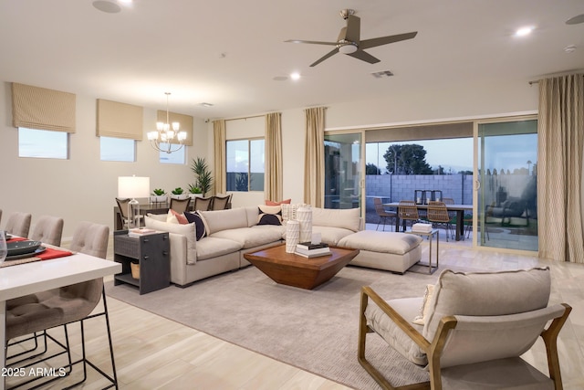 living room featuring ceiling fan with notable chandelier and light hardwood / wood-style floors