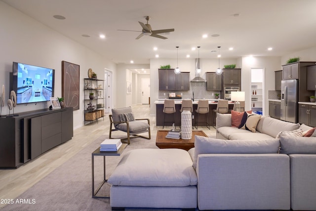 living room with sink, light hardwood / wood-style flooring, and ceiling fan