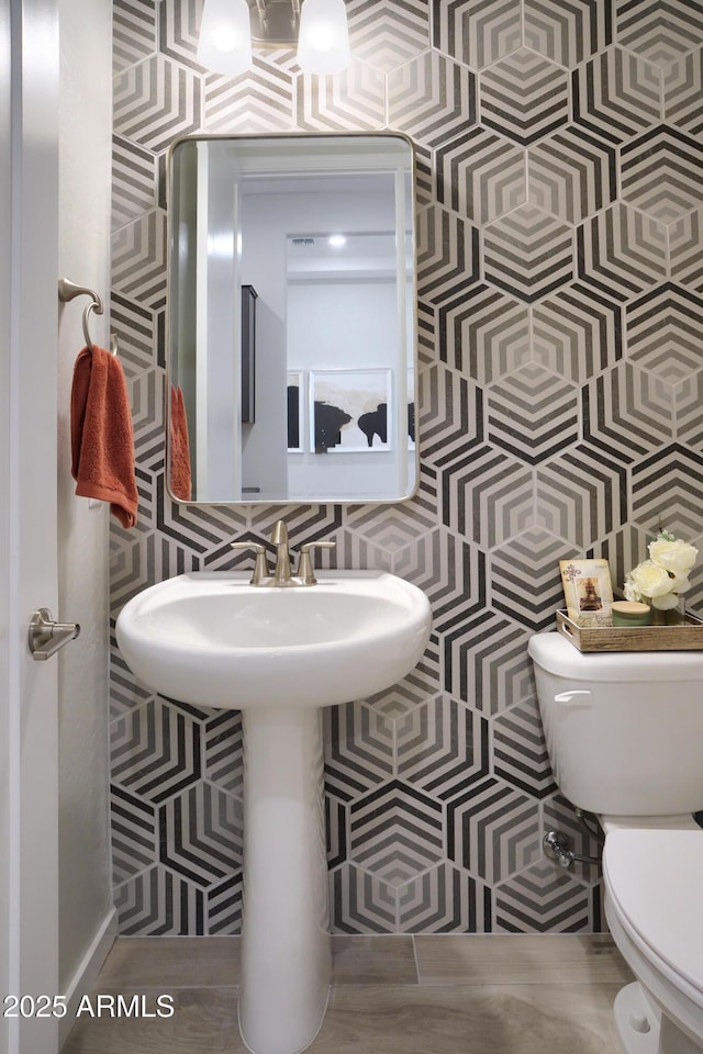 bathroom with tile walls and toilet