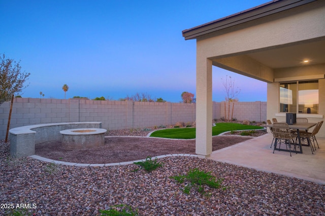 yard at dusk with an outdoor fire pit and a patio area