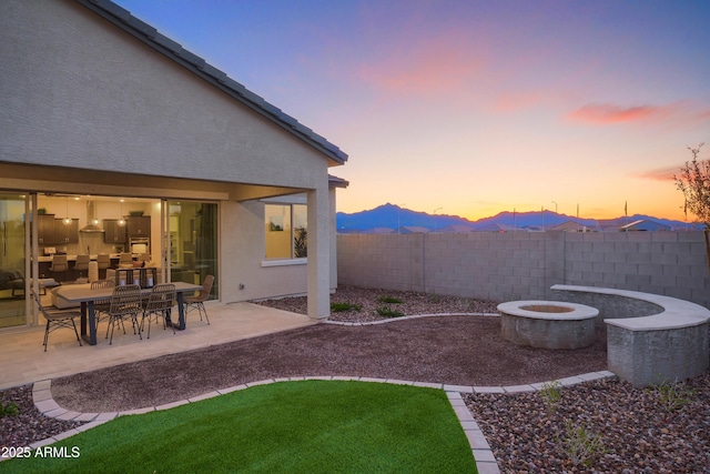 yard at dusk with a patio area and an outdoor fire pit