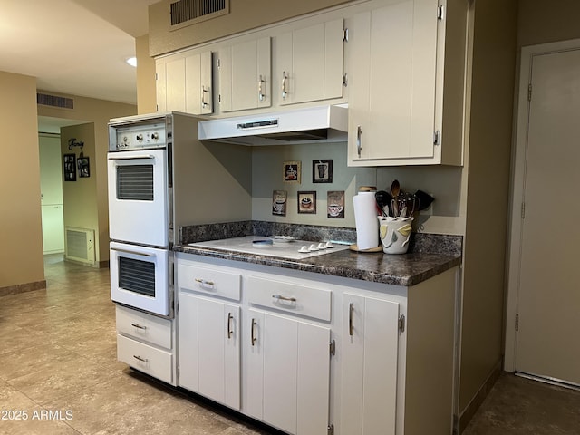 kitchen featuring white cabinetry and white appliances