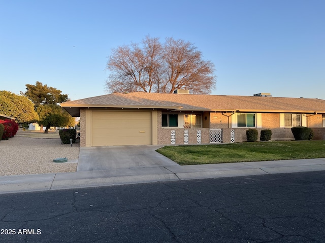 ranch-style house featuring a garage and a front lawn