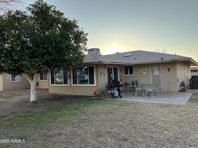 back house at dusk with a patio