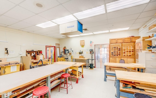 miscellaneous room featuring a drop ceiling and a workshop area