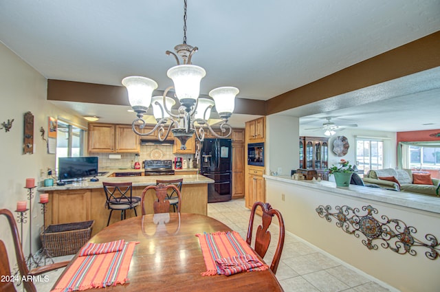 tiled dining area featuring ceiling fan with notable chandelier