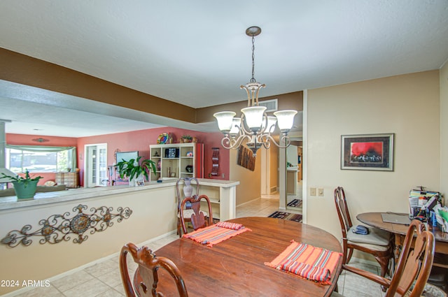 dining space featuring light tile patterned flooring and an inviting chandelier