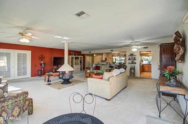 carpeted living room featuring ceiling fan and decorative columns