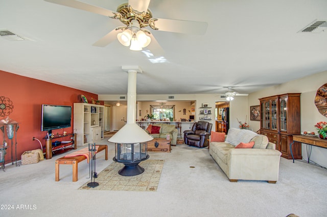 carpeted living room featuring ceiling fan and decorative columns