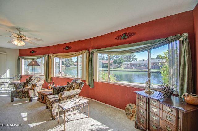 sunroom with a water view and ceiling fan