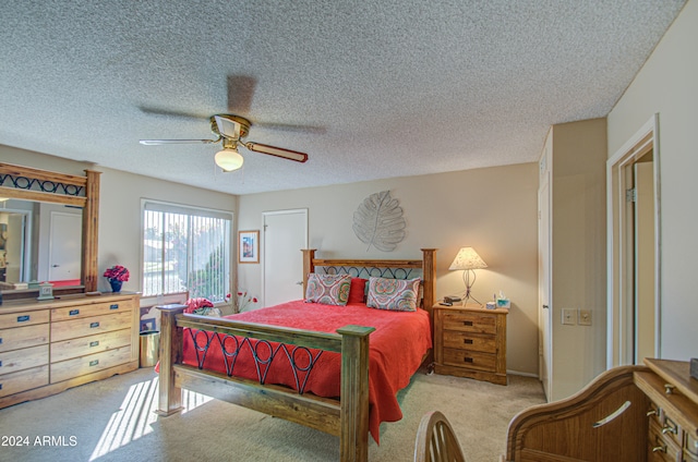 carpeted bedroom featuring a textured ceiling and ceiling fan