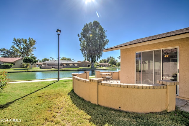 view of yard featuring a water view and a patio