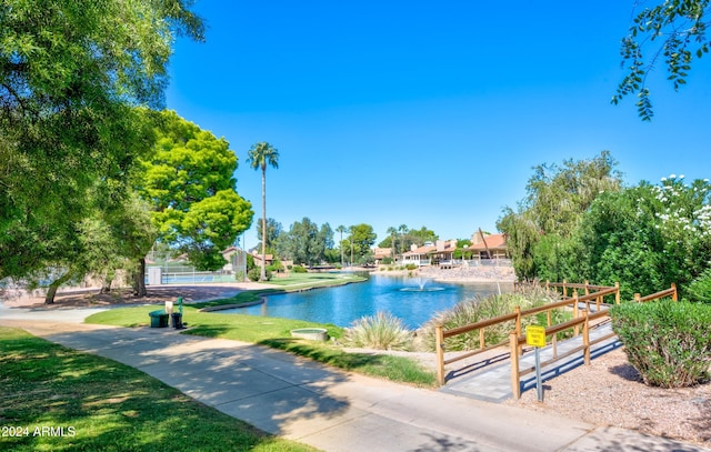 view of swimming pool featuring a water view and a yard