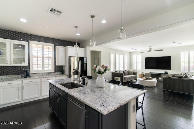 kitchen featuring dark wood-style floors, a sink, visible vents, white cabinetry, and appliances with stainless steel finishes