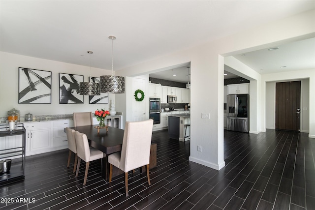 dining area with baseboards, wood tiled floor, and recessed lighting