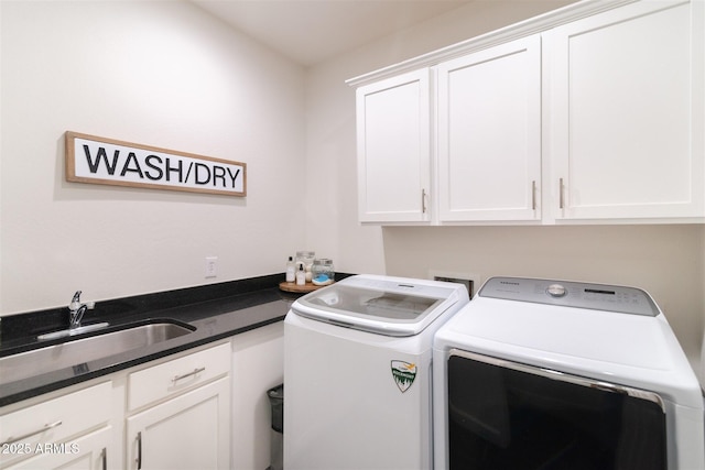 clothes washing area with washing machine and dryer, a sink, and cabinet space