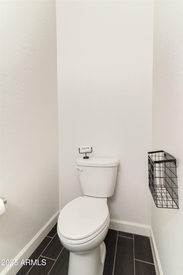 bathroom featuring baseboards and toilet