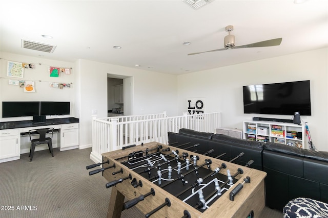 rec room with carpet floors, a ceiling fan, visible vents, and built in desk