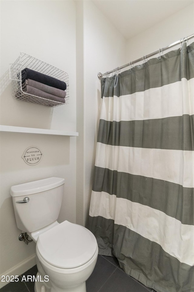 bathroom with tile patterned flooring, a shower with shower curtain, and toilet