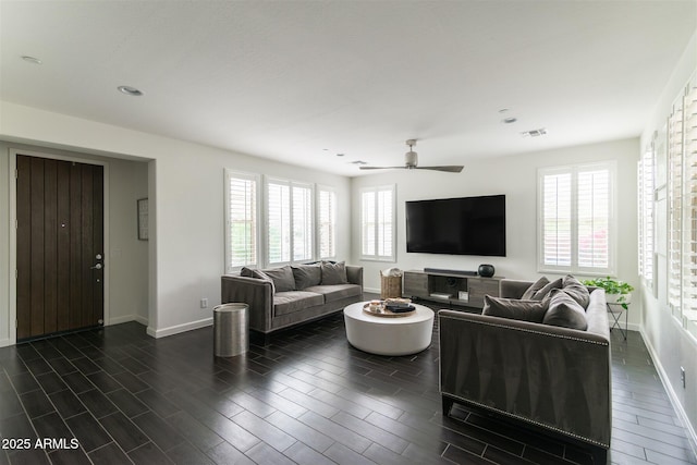 living area featuring plenty of natural light, baseboards, and ceiling fan