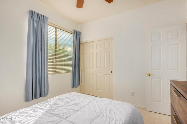 carpeted bedroom featuring a closet and ceiling fan