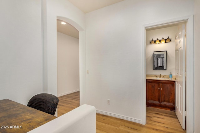 home office featuring sink and light hardwood / wood-style flooring