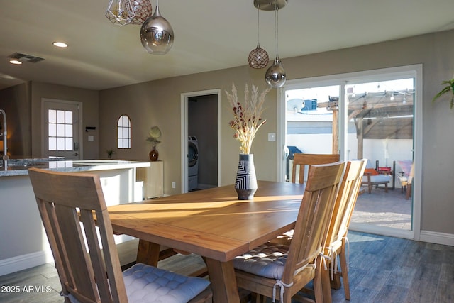 dining room with dark hardwood / wood-style flooring and washer / clothes dryer