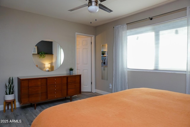 bedroom with dark hardwood / wood-style flooring, ceiling fan, and multiple windows