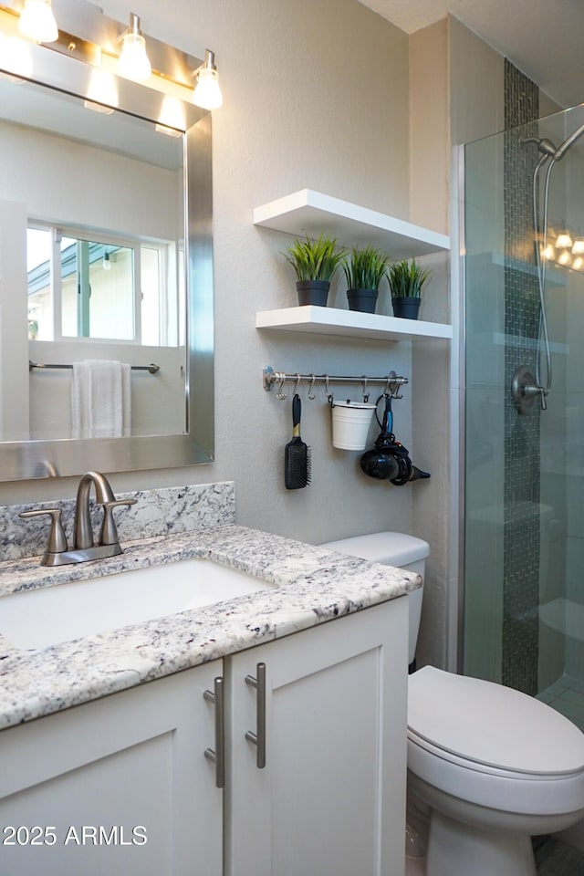 bathroom featuring toilet, walk in shower, and vanity