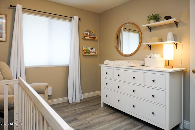 bedroom with a crib and hardwood / wood-style floors