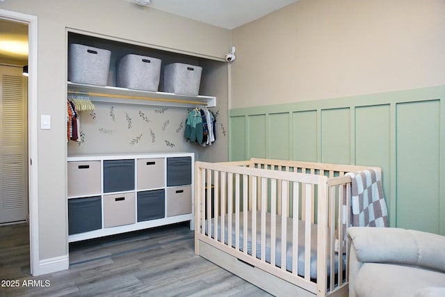 bedroom featuring hardwood / wood-style flooring and a nursery area