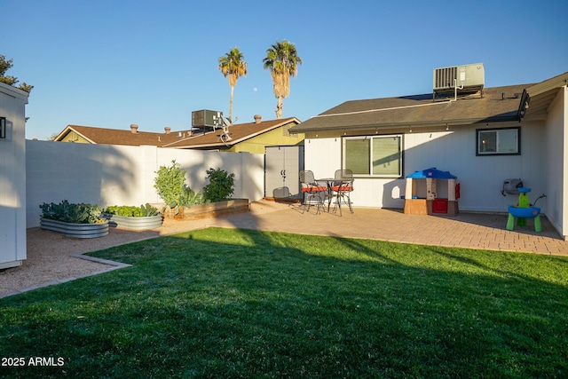 back of property featuring a yard, a patio area, and central AC