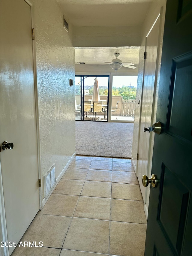 3340 W State Route 89a Unit 9, Sedona, AZ 86336 - hallway with tile patterned floors, a textured wall, carpet floors, and baseboards