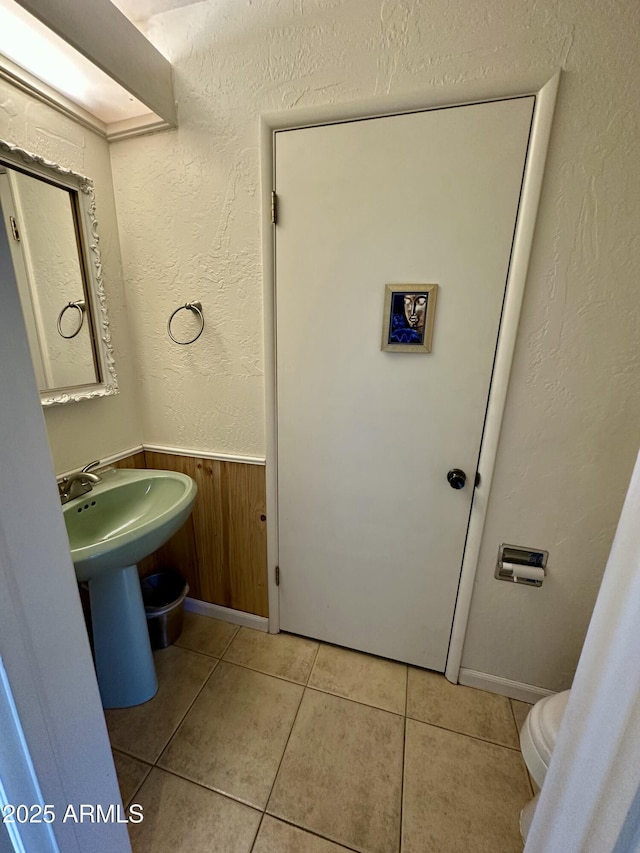 3340 W State Route 89a Unit 9, Sedona, AZ 86336 - half bathroom with tile patterned flooring, wainscoting, toilet, and a textured wall