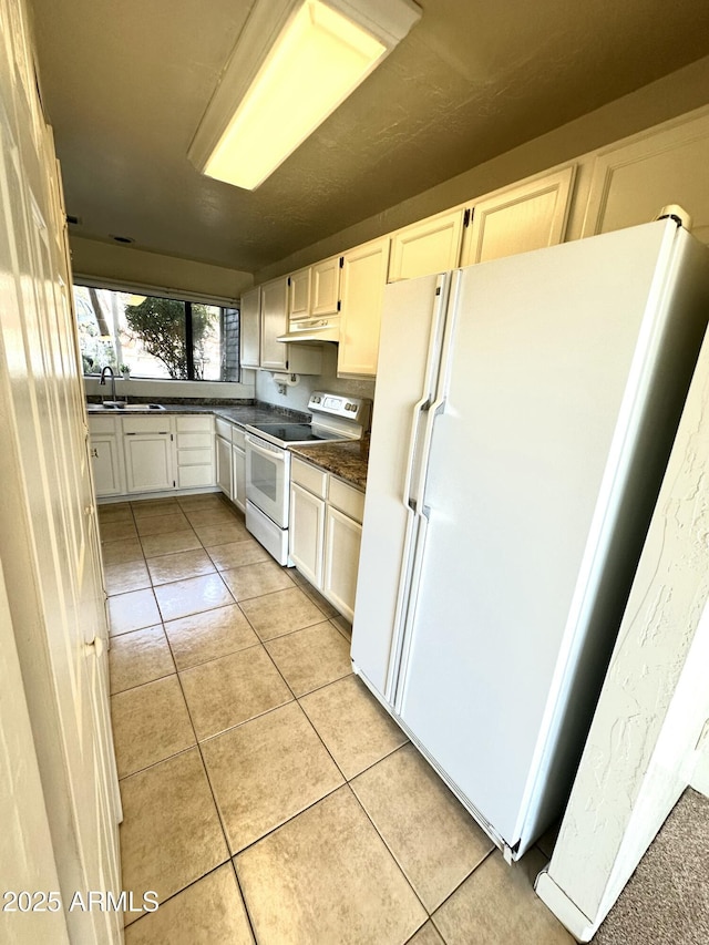 3340 W State Route 89a Unit 9, Sedona, AZ 86336 - kitchen featuring white appliances, a sink, under cabinet range hood, dark countertops, and light tile patterned floors