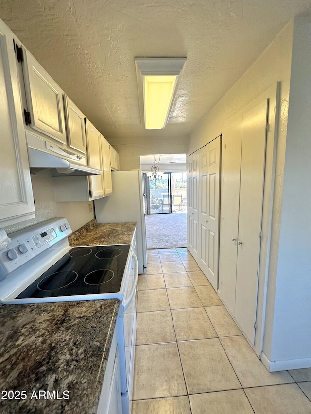 3340 W State Route 89a Unit 9, Sedona, AZ 86336 - kitchen featuring white appliances, dark countertops, light tile patterned floors, under cabinet range hood, and a textured ceiling