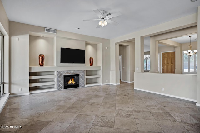 13945 E Gail Rd, Scottsdale, AZ 85259 - unfurnished living room with built in shelves, a tile fireplace, a ceiling fan, and a chandelier