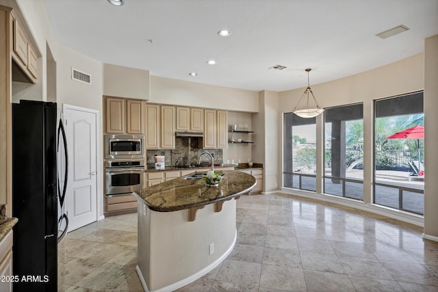 13945 E Gail Rd, Scottsdale, AZ 85259 - kitchen featuring appliances with stainless steel finishes, backsplash, dark stone counters, a center island with sink, and recessed lighting