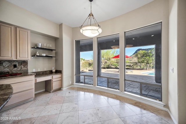13945 E Gail Rd, Scottsdale, AZ 85259 - unfurnished dining area with built in desk, plenty of natural light, and light tile patterned flooring