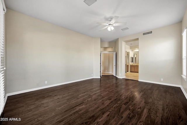 13945 E Gail Rd, Scottsdale, AZ 85259 - unfurnished bedroom with dark wood-style flooring, ensuite bathroom, ceiling fan, and multiple windows