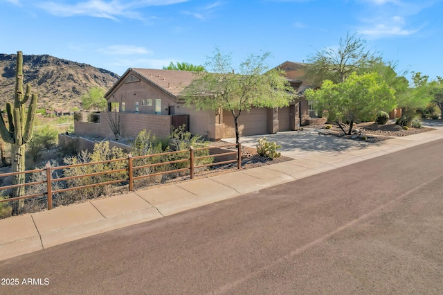 13945 E Gail Rd, Scottsdale, AZ 85259 - view of front of house with driveway, an attached garage, stucco siding, and a mountain view