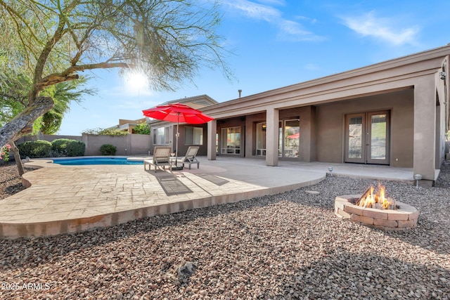 13945 E Gail Rd, Scottsdale, AZ 85259 - back of property featuring french doors, an outdoor fire pit, stucco siding, a fenced backyard, and a patio area