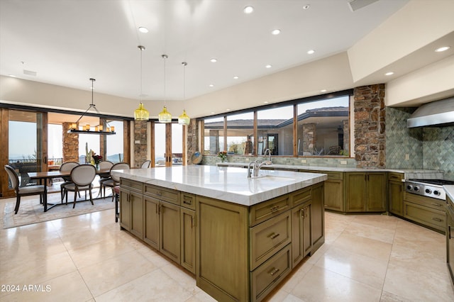11070 E Rolling Rock Dr, Scottsdale, AZ 85262 - kitchen with a large island with sink, decorative backsplash, a sink, stainless steel gas stovetop, and light stone counters