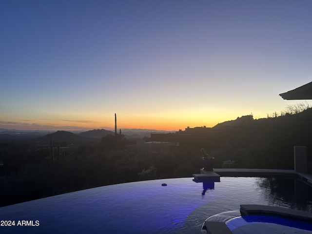 11070 E Rolling Rock Dr, Scottsdale, AZ 85262 - pool at dusk featuring a pool with connected hot tub